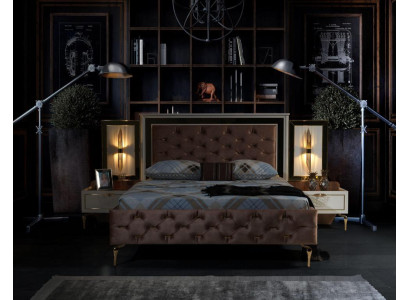 Élégant lit de confort Chesterfield avec des jambes dorées et des tables de chevet assorties.